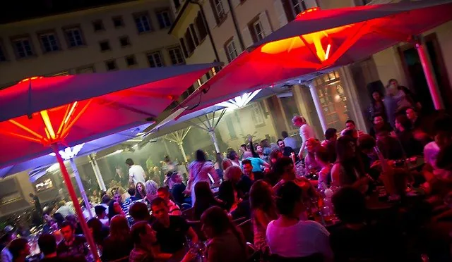 La terrasse du QG le soir, parasols éclairés en rouge
